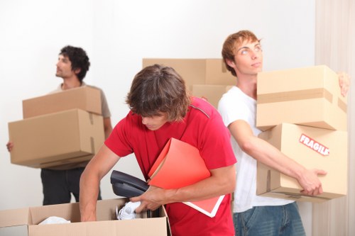 Trained Wimbledon movers using proper lifting techniques during a relocation